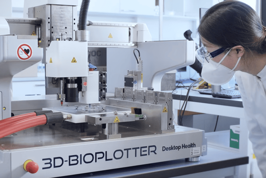 the 3D printer Bioplotter 3D printing an implant. A scientist standing next to the machine